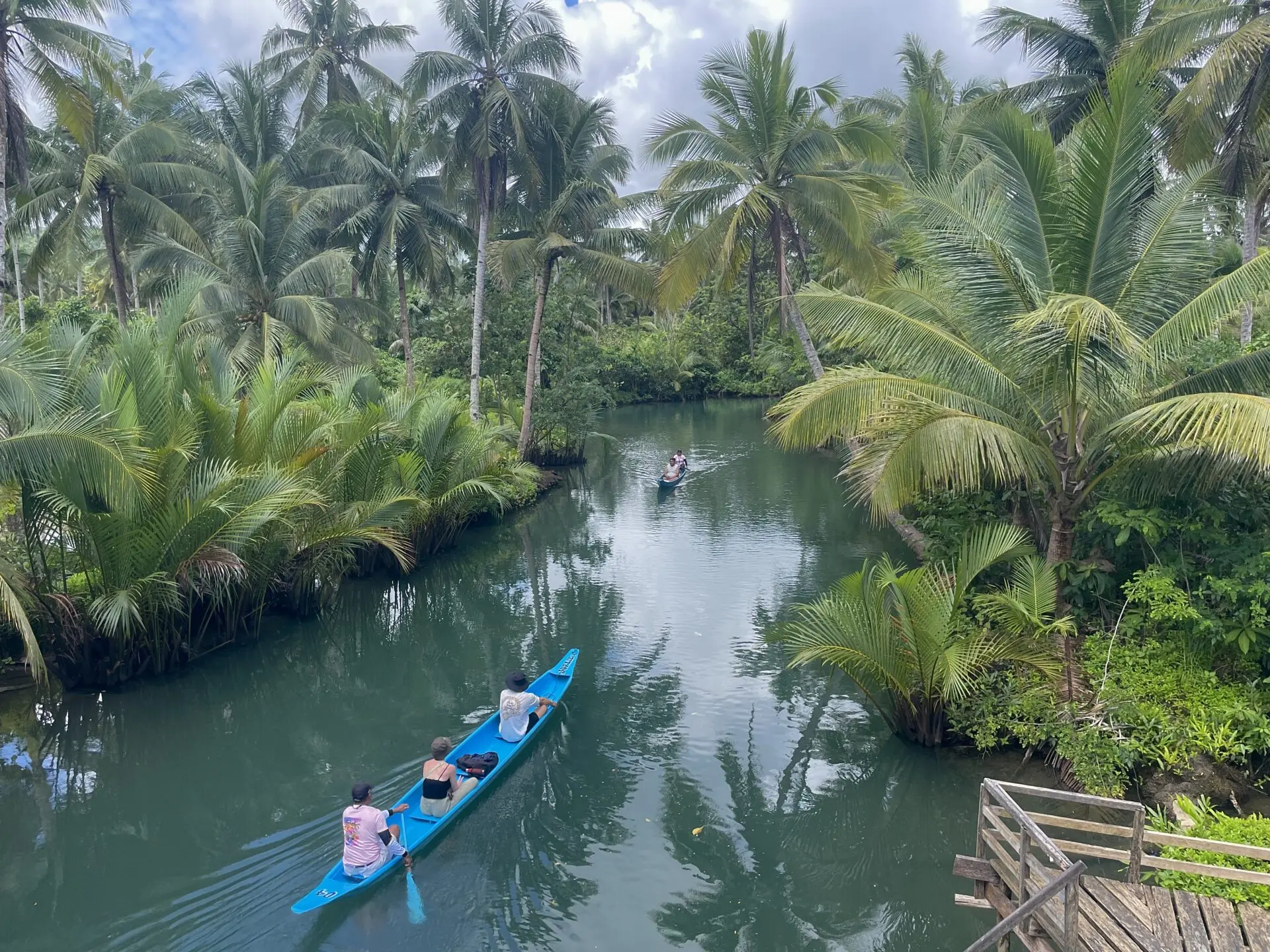 Couple kayaking through palm-lined Maasin River on Siargao Island